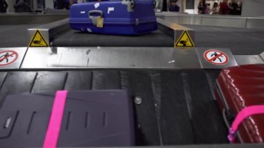 4k, havaalanı uluslararası terminal binasının varış salonundaki bagaj teslim yerinde valiz taşıma bandındaki bavul. Bagaj bekleme alanı, yolculuk konsepti - Dan