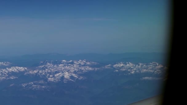 雪に覆われた山々と翼 フランス語とスペイン語のピレネー山脈の航空窓からの眺め ヨーロッパのスペインの山の峰の飛行機から見たダン — ストック動画