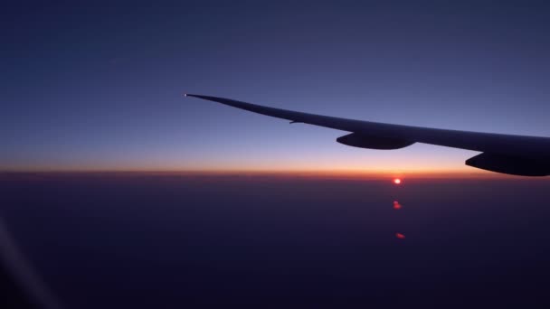 Blick Auf Den Flugzeugflügel Mit Dem Sonnenuntergang Durch Ein Flugzeugfenster — Stockvideo