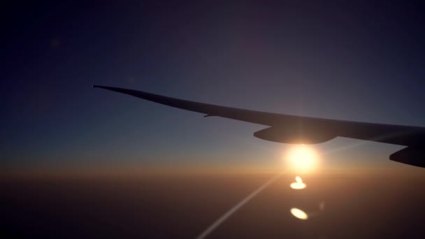 飛行機の旅で飛行機の窓から夕日と飛行機の翼の眺め 空気で旅 飛行機の美しい夜明けの太陽と飛んでいる 休暇旅行のコンセプト — ストック動画