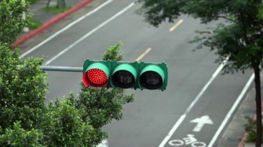 Trafik ışıklarının yavaş çekimde kırmızıdan yeşil renge dönüşmesi, ilerlemek için sinyal açık. Ağaçlı Asya Taipei şehir yolu. Tayvan-Dan kavşağındaki Semaphore ışıkları