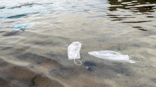 Covid 19時代の廃棄物 海のコロナウイルス単回使用フェイスマスクに捨て 環境汚染や海岸プラスチック汚染 海の健康を脅かす海岸のゴミ — ストック写真