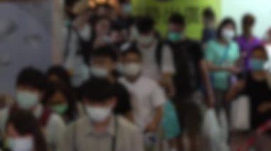 Tren istasyonuna giden metro girişindeki bulaşıcı hastalıklara karşı koruyucu maske takan Asyalıların bulanık görüntüsü. Coronavirus koruması - Dan