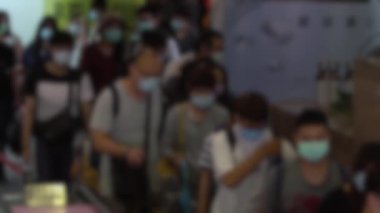 Yavaş çekim, metroda yürüyen merdivende cerrahi maske takan kalabalığın odaklanmış görüntüsünü bulanıklaştırdı. Coronavirus pnömonisi birçok şehre yayılıyor. 2019-NCoV salgını Çin.