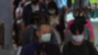 Yavaş çekimde, bulaşıcı hastalıklara karşı koruyucu maske takan ve toplu taşımacılığın yürüyen merdivenlerinde grip salgını önleyen insanların odaklanmış görüntüsü bulanıklaştı. Coronavirus-Dan
