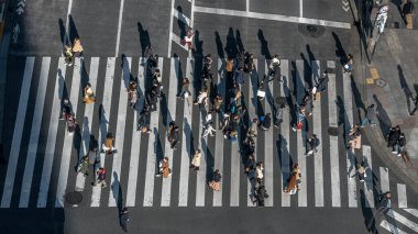 Gün batımında Japon yaya geçidi kalabalığının üzerinde. Tokyo 'nun en işlek kavşağında yürüyen Asyalıların manzarası yükseliyor.