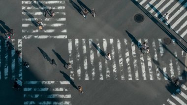 Gün batımının ışığıyla kavşakta Japon yaya geçidi kalabalığının manzarası yükseldi. Japonya 'nın kalabalık yaya geçidinde Asyalıların hava görüntüsü.