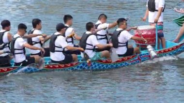 Taipei, Tayvan-08 Haziran 2024: Taipei kürekçisinin yavaş çekim kuvveti, ılık ışık altında hafif parıldayan gölün kenarından yavaşça kürek kaldırıyor.