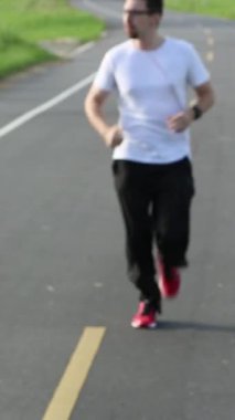 Road Runner beyaz bir adam koşuyor ve Taipe şehrinde müzik çalıyor ve koşudan sonra kulaklıkları çıkarıyor. Egzersiz Konsepti. Spor yaşam tarzı.