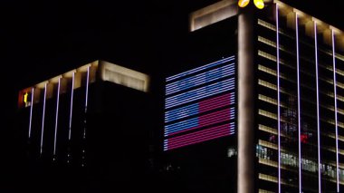 Tayvan bayraklarının yavaş hareket etmesi şehir kutuplarında gece aydınlatması, ulusal gururu şehir içi gece arkaplanıyla gözler önüne seriyor.