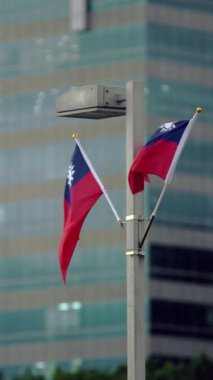 Arka planda modern vatanseverliği ve kültürü sembolize eden şehir manzaralı Tayvan bayrağının dikey yavaş hareketi.