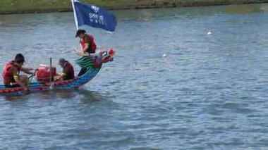 Taipei, Tayvan-08 Haziran 2024: Taipei kürekçisinin yavaşça kürek çekmesi altın saatinde parlayan gölün tam kenar görüntüsü.