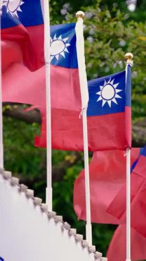 Vertical Slow motion of multiple Taiwan flags arranged under a concrete roof, showcasing patriotism and national pride in an organized urban setting.