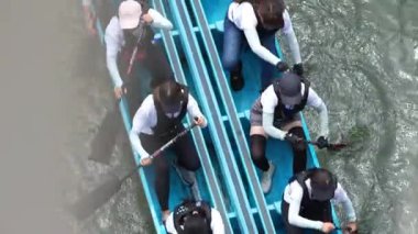 Taipei, Taiwan-08 June, 2024: Slow motion of Taipei paddler gliding quietly near dock, shot from side with paddle resting and warm light on face.