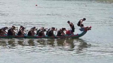 Taipei, Taiwan-08 June, 2024: Slow motion of Taipei paddler sitting still in boat, paddle across lap, backlight reflections softly shimmering.