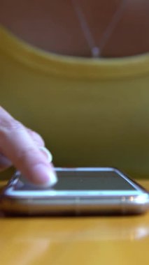 4K Asian Woman Using Smartphone on table of coffeeshop. Touch screen to chat and contact people. Good time to surfing the internet, checks social network on her phone device near to sunglasses