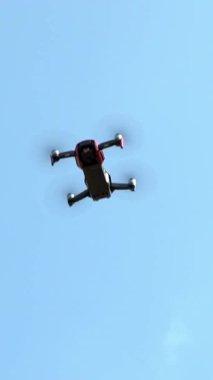 Keelung, Taiwan-09 August, 2018: Slow motion drone with remote control flying overhead in blue sky. Unmanned helicopter flight with digital camera. Quadrocopter takes professional photos and video