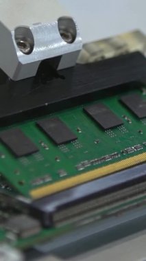 Factory machinery at work. PCB Processing on CNC machine. Production of electronic components at high-tech factory. Circuit board being assembled with automated robotic arm.