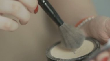 genç bir kızın eli bir palet bir fırça ile bir göz farı alır ve çok fazla eziyor, bir kadın kozmetik, bir güzellik konsepti ve bir gençlik yaşam tarzı ile makyaj yapar