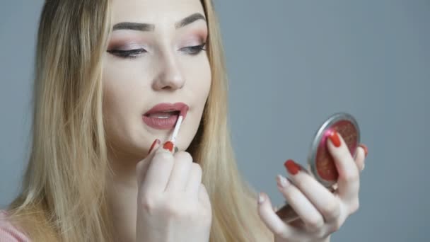 앞에서 메이크업을하는 아름다운 여성은 스튜디오 화장품과 아름다움의 개념에 그녀의 입술을 — 비디오