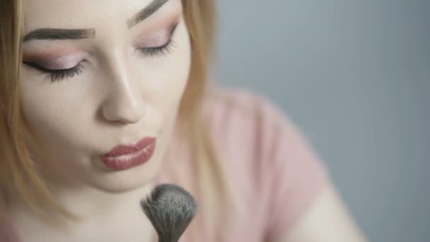 소녀는 푹신한 브러시로 과잉을 스튜디오 메이크업 아름다움과 화장품 개념과 여성의 — 비디오