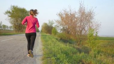Pistte koşan genç bir kadın spor yapıyor, kilo vermek için koşan bir kız, sağlıklı yaşam tarzı konsepti, diyet, doğada spor