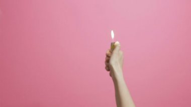 kadın el çakmak açar ve dalgalar pembe renk stüdyo arka plan üzerinde bir pırıltı, fan ışık, yaratıcı fikir ateşe