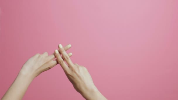 在粉红色的工作室背景的女孩交叉手指 显示标签形状的手 概念社交网络 字幕屏幕保护程序 — 图库视频影像