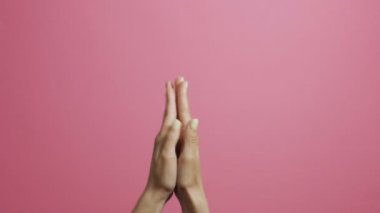 pembe bir stüdyo arka plan üzerinde sevinçle alkışlayan genç bir kadının elleri