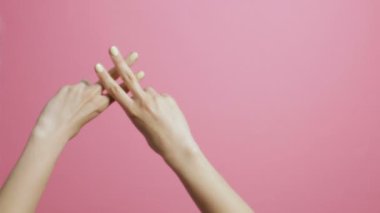pembe stüdyo arka plan üzerinde bir kızın çapraz parmakları, bir hashtag şekli gösteren eller, kavram sosyal ağlar, indeksleme, altyazılar için bir ekran koruyucu