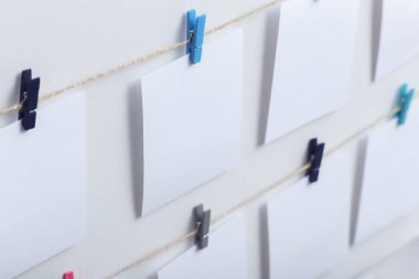 beyaz arka plan üzerinde bir iplik üzerinde renkli clothespins asılı boş beyaz kartlar, bir fotoğraf kolaj için bir şablon, anılar kavramı ve bir fotoğraf endüstrisi