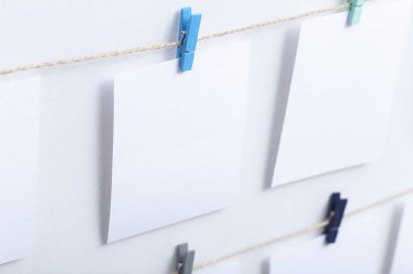 beyaz arka plan üzerinde bir iplik üzerinde renkli clothespins asılı boş beyaz kartlar, bir fotoğraf kolaj için bir şablon, anılar kavramı ve bir fotoğraf endüstrisi
