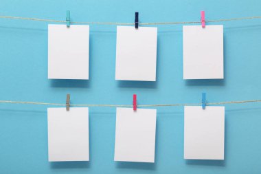 yaşam anlarının fotoğraf kartları için yer, renkli bir arka plan üzerinde kırtasiye klipleri ile keten bir ipe bağlı boş boşluklar, metin için bir kavram şablonu, görüntüler, ev dekorasyonu için fikir