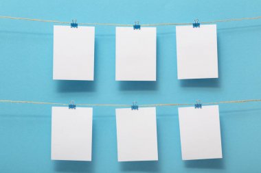 yaşam anlarının fotoğraf kartları için yer, renkli bir arka plan üzerinde kırtasiye klipleri ile keten bir ipe bağlı boş boşluklar, metin için bir kavram şablonu, görüntüler, ev dekorasyonu için fikir