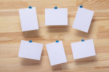 ahşap tahtanın arka planında keten halat üzerine renkli kelepçe ile bağlı boş kağıt kartlar, görüntü veya metin için boş şablonlar, konsept fotoğraf dekoru