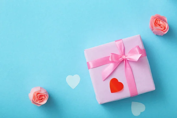 Achtergrond van geschenken met confetti harten en rozen, dozen verpakt in decoratief papier op Pastel gekleurde blauwe achtergrond, vakantie concept en liefde — Stockfoto