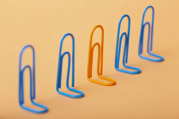 Oranje clip onder de blues, niet-gelijkenis met anderen, het concept van individualiteit, optimisme, creatief idee met Office paperclips, concept van de psychologie — Stockfoto