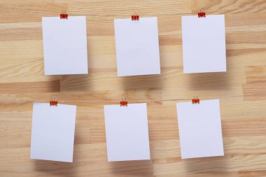 ahşap tahtanın arka planında keten halat üzerine renkli kelepçe ile bağlı boş kağıt kartlar, görüntü veya metin için boş şablonlar, konsept fotoğraf dekoru