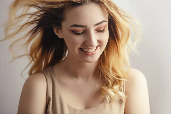 Retrato de estudio de una hermosa chica que ríe sinceramente, cara de mujer joven con el pelo rizado desaliñado del viento, el concepto de belleza natural, cuidado del cuerpo, cosméticos — Foto de Stock