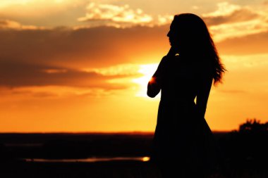 gün batımında bir alanda rüya gibi bir kız siluet, doğanın tadını genç bir kadın