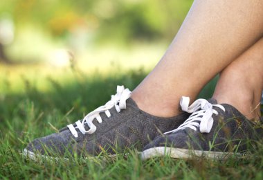 çim yeşil çim üzerinde beyaz bağcıklar ile yeni spor ayakkabı kadın arka plan