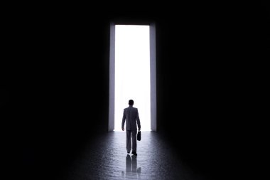 bilinmeyene kapı açmak için adım yapımında bir evrak çantası ile bir iş elbisesi içinde bir adamın silueti, yaşam seçimleri ve iş kavramı