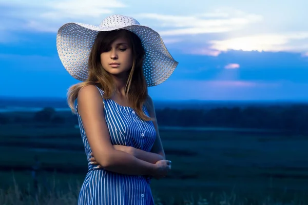 戏剧性的肖像，一个美丽的女孩在外地的帽子，一个年轻女子走在夏天的户外 — 图库照片