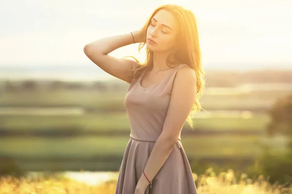 Retrato de una chica de ensueño en un campo cerró los ojos y disfrutó de la naturaleza — Foto de Stock