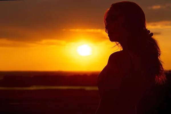 Silhouette di una bella ragazza romantica al tramonto, profilo viso di giovane donna con i capelli lunghi in tempo caldo — Foto Stock