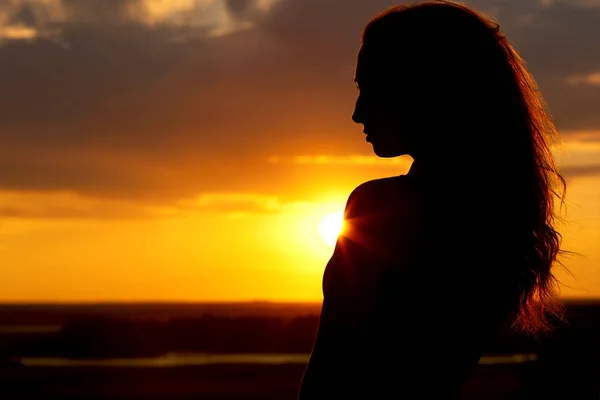 Silhouette of a beautiful girl at sunset, face profile of young woman enjoying nature — Stock Photo, Image