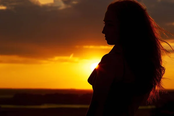 Silhouette di una bella ragazza romantica al tramonto, profilo viso di giovane donna con i capelli lunghi in tempo caldo — Foto Stock