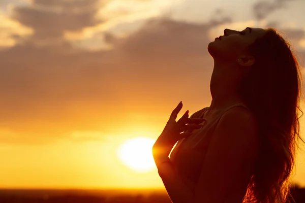 Silhouette d'une belle fille au coucher du soleil dans un champ, profil visage de jeune femme — Photo