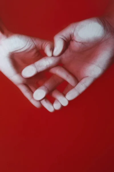 Πλέγμα των χεριών ενός άντρα και μιας γυναίκας σε σχήμα καρδιάς σε κόκκινο νερό, έννοια της αγάπης και της πίστης, τέχνη μυστηρίου — Φωτογραφία Αρχείου