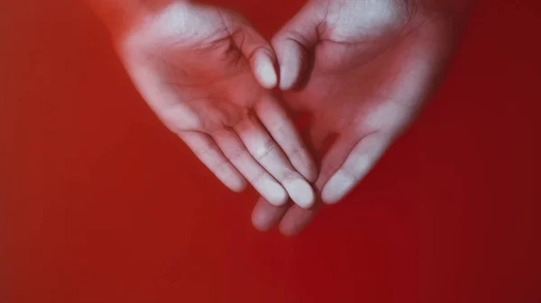 Kezében egy szerető pár préselt pálmák üveg vörös vízben, az ember és a nő keze alakú szív, koncepció szeretet és érzések, titokzatos művészet — Stock Fotó
